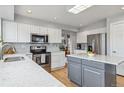 Bright kitchen features white cabinetry, stainless steel appliances, and marble countertops at 12551 W 84Th Cir, Arvada, CO 80005