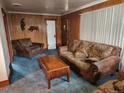 Cozy living room with wood-paneled walls, comfortable seating, and a wooden coffee table at 3036 W Clyde Pl, Denver, CO 80211
