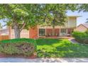 Brick home with lush front lawn, mature trees, and a cozy porch swing for relaxed outdoor living at 3752 S Helena Way, Aurora, CO 80013