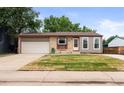 Single-Gathering home featuring a grass yard and attached one car garage in a residential neighborhood at 5167 Sable St, Denver, CO 80239