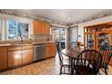 Bright kitchen featuring wood cabinets, stainless steel appliances, tile flooring, and an adjacent breakfast nook at 16505 E Arkansas Ave, Aurora, CO 80017