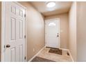 A clean entryway featuring a white front door, neutral tile flooring, and fresh paint at 8540 Corona St, Denver, CO 80229
