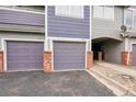 Multiple garages with brick accents offer private parking in front of the townhome, highlighting its design and convenience at 1308 S Danube Way # 102, Aurora, CO 80017