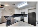 Cozy kitchen boasts black appliances and countertops, paired with white cabinets at 1308 S Danube Way # 102, Aurora, CO 80017