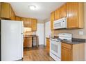 A kitchen featuring wooden cabinets, white appliances and granite-like countertops at 1060 Saulsbury St, Lakewood, CO 80214