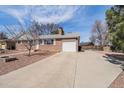 Exterior view showcasing the home's brick facade and long driveway to the attached garage at 1008 Yeager Dr, Longmont, CO 80501