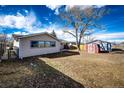 Spacious backyard with mature trees and a small storage shed, ideal for outdoor enjoyment at 750 4Th St, Bennett, CO 80102