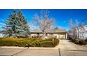 Street view of home, showcasing its well-maintained yard, brick accents, and single-car garage at 750 4Th St, Bennett, CO 80102