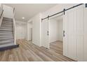 Bright entryway with light wood floors and a staircase, plus a barn door entrance at 13640 E Iliff Pl, Aurora, CO 80014