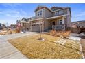 Inviting two-story home featuring a cozy porch, neutral siding, and a two-car attached garage at 1043 S Fultondale Ct, Aurora, CO 80018