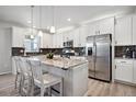 Bright kitchen with granite countertops, stainless steel appliances, and a center island with seating at 1043 S Fultondale Ct, Aurora, CO 80018
