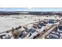 Winter aerial view of a charming home in a serene neighborhood, boasting snow-covered streets and beautiful landscaping at 1180 Crenshaw St, Castle Rock, CO 80104