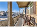Relaxing front porch with seating, offering a comfortable outdoor space to enjoy the neighborhood at 222 Fox St, Bennett, CO 80102