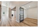 Bright hallway featuring an open floor plan with views of the kitchen and a glass paneled door leading to another room at 2816 Greensborough Dr, Highlands Ranch, CO 80129