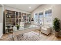 Cozy office featuring built-in bookshelves, a modern desk, and natural light from the window at 2816 Greensborough Dr, Highlands Ranch, CO 80129