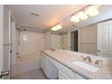 Bright bathroom featuring a long vanity, granite countertop, double sinks, and tub-shower combo at 1785 Morrison Ct, Superior, CO 80027