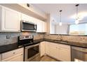 Modern kitchen featuring stainless steel appliances, tile backsplash, and white cabinetry at 1785 Morrison Ct, Superior, CO 80027