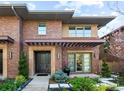 Inviting brick home showcasing a pergola, manicured landscaping and covered entryway at 318 Adams St, Denver, CO 80206
