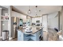 Bright kitchen boasts a large island, granite counters, stainless appliances, and a view of the staircase at 4826 S Ireland St, Aurora, CO 80015
