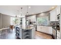 Modern kitchen featuring a large island with granite countertops, stainless steel appliances, and hardwood floors at 4826 S Ireland St, Aurora, CO 80015