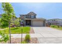 Charming home boasts manicured lawn, stone accents, and a wide driveway leading to a spacious two car garage at 9350 Dunraven St, Arvada, CO 80007