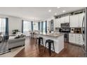 Open-concept kitchen, dining, and living area with hardwood floors and modern finishes at 9350 Dunraven St, Arvada, CO 80007