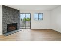 Bright living room with stone fireplace and sliding door access to the balcony at 3100 S Federal Blvd # 232, Denver, CO 80236