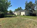 Expansive backyard with a well-maintained lawn and mature trees providing shade at 19645 E Buchanan Pl, Aurora, CO 80011