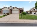 Street view showcasing the home's brick and vinyl exterior, driveway, and small lawn at 2040 Yarrow St, Lakewood, CO 80214
