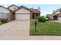 Street view showcasing the home's brick and vinyl exterior, driveway, and small lawn at 2040 Yarrow St, Lakewood, CO 80214