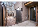 Private backyard area with a wooden gate and brick exterior, offering a secluded outdoor space at 1632 N Gilpin St, Denver, CO 80218