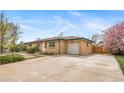 Ranch style house showing a driveway, a garage, and a basketball hoop behind a fence at 6625 S Ogden St, Centennial, CO 80121