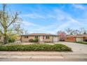 Charming brick home featuring an attached garage, landscaped front yard, and a beautifully maintained lawn at 6625 S Ogden St, Centennial, CO 80121