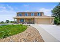 Inviting two-story home featuring a brick facade, covered front porch, and manicured lawn at 3298 W 11Th Avenue Pl, Broomfield, CO 80020