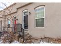 Two-story building with dark brown door and metal railing at 2512 Kensing Ct, Denver, CO 80211