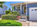 Charming front porch with decorative details, including a wreath, plants, and landscaping. Located in suburban neighborhood at 1201 Trout Creek Cir, Longmont, CO 80504