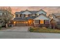 Charming home with a two-car garage, brick accents, and manicured lawn at dusk at 1609 S Catawba Cir, Aurora, CO 80018