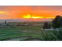 Picturesque view of the sunset over a sprawling green landscape and distant mountain range at 1609 S Catawba Cir, Aurora, CO 80018