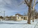 Tan house with snow covered yard, large tree at 8501 E 104Th Ave, Henderson, CO 80640