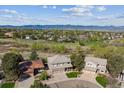 Expansive aerial shot of a residential neighborhood with mountain views in the background, showcasing lush greenery and diverse homes at 9531 Desert Willow Way, Highlands Ranch, CO 80129