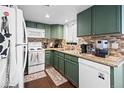 Well-lit kitchen with olive green cabinets, granite countertops, and modern appliances at 970 S Dawson Way # 9, Aurora, CO 80012