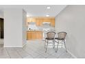 Bright kitchen with ample cabinet space, white appliances, and breakfast bar seating at 2500 S York St # 115, Denver, CO 80210