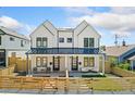 Modern farmhouse exterior showcasing dual units with black metal roofs and fenced front yards at 2426 Ames St, Edgewater, CO 80214
