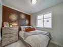 Charming bedroom featuring a stylish dresser, decorative wall art, and a comfortable bed at 10307 Vaughn Way, Commerce City, CO 80022