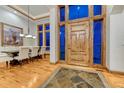 Elegant foyer with a large wooden door, stone flooring, and views of the dining area at 2597 Oak Vista Ct, Castle Rock, CO 80104