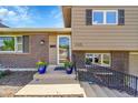 Charming front entrance featuring brick accents, decorative flower pots, and a secure wrought iron railing at 9225 Lowell Blvd, Westminster, CO 80031