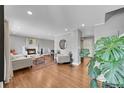 Open living room featuring hardwood floors, a cozy fireplace, and neutral paint, great for relaxing at 9225 Lowell Blvd, Westminster, CO 80031