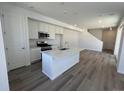 Bright, open kitchen featuring an island, modern appliances, and white cabinetry at 6658 N Nepal Ct, Aurora, CO 80019