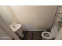 Cozy powder bathroom offers a pedestal sink, toilet and wood look floors at 47375 Lilac Ave, Bennett, CO 80102