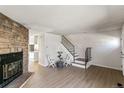 Bright living room with a cozy fireplace, wood floors, and staircase at 1620 S Ivory Cir # C, Aurora, CO 80017